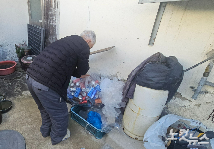 이두희씨가 고물상에 내다 팔 음료수 캔을 모으고 있다. 임성민 기자
