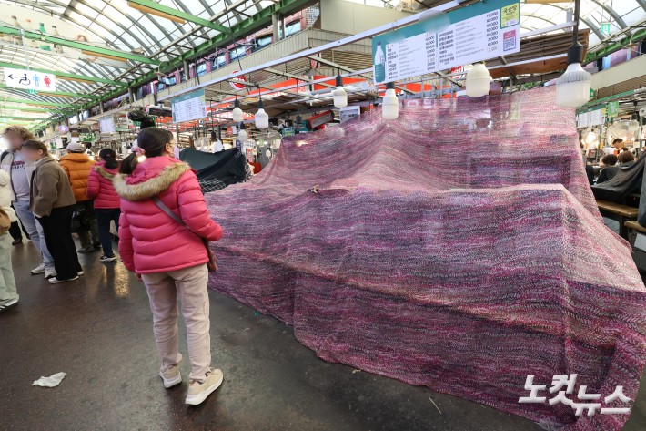 한 유튜버의 광장시장 방문 영상을 계기로 바가지요금 논란이 불거진 서울 광장시장의 한 노점에 영업정지 10일 처분이 내려진 가운데 12일 서울 종로구 광장시장에서 순대 등 분식을 파는 해당 노점이 천막으로 덮여 있다.앞서 지난 4일 구독자 151만명을 거느린 유튜버 