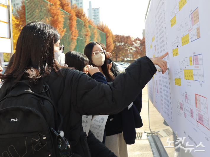 수험생들이 게시판에 붙어있는 수험번호 구간표와 시험실 배치도를 확인하고 있다. 임성민 기자