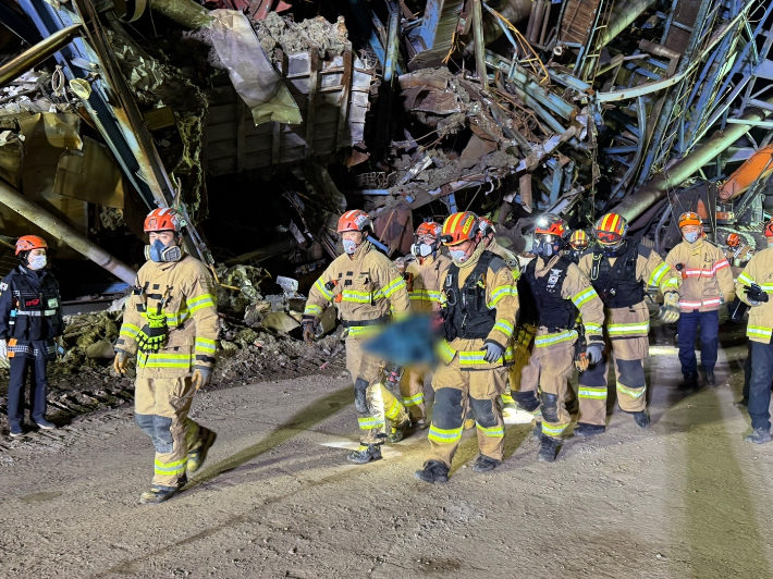 13일 오전 울산화력발전소 보일러 타워 붕괴사고 현장에서 소방대원들이 매몰자 1명의 시신을 수습하고 있다. 울산소방본부 제공