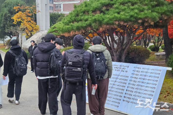 13일 오전 7시 30분쯤 강원 춘천고교 정문에 놓여진 수험장 입실 안내문을 확인하고 수험장으로 향하는 학생들 모습. 구본호 기자