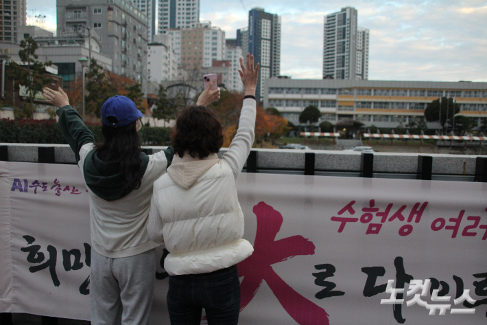 13일 울산시교육청 제28지구 23시험장 울산여자고등학교 교문 옆에서 가족들이 수험생에게 손을 흔들고 있다. 반웅규 기자 