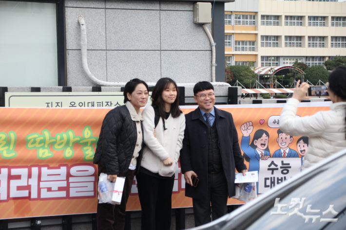 수험생을 응원하는 교회 식구들이 함께 시험장 앞에서 기념촬영을 하고 있다. 반웅규 기자 