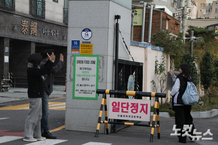 수험생 가족들이 시험장 앞에서 손을 흔들고 있다. 반웅규 기자 