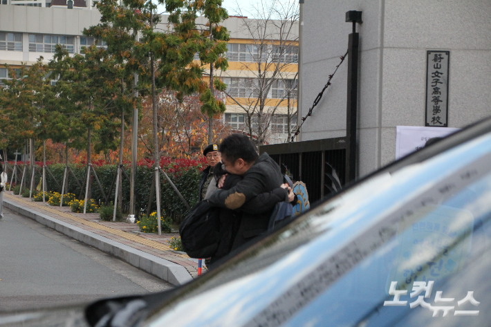 수험생 가족이 시험장 앞에서 서로 안아주고 있다. 반웅규 기자