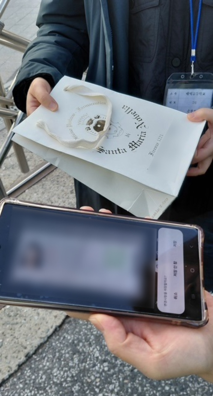 수험생 학부모에게 인계받은 도시락을 학교 관계자에게 전달하는 모습. 대전경찰청 제공