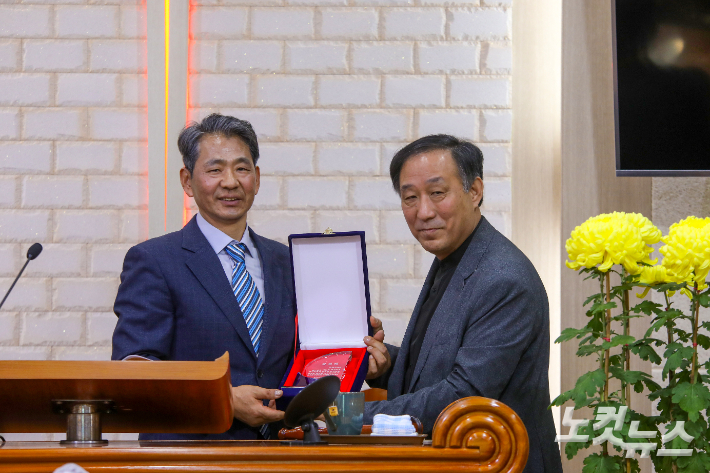 신임 회장 신명악 목사(왼쪽)가 이임하는 임영식 목사(오른쪽)에게 공로패를 전달하고 있다. 최화랑 기자