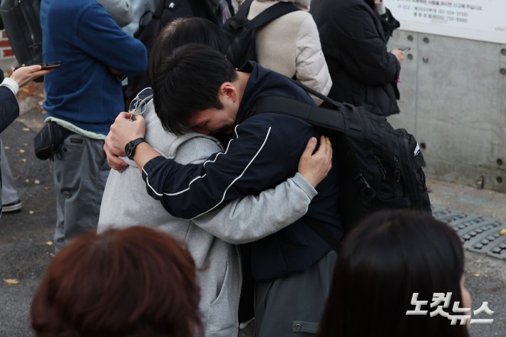2026학년도 대학수학능력시험일인 13일 오후 서울 종로구 경복고등학교에서 시험을 마친 수험생이 학부모와 포옹하고 있다.