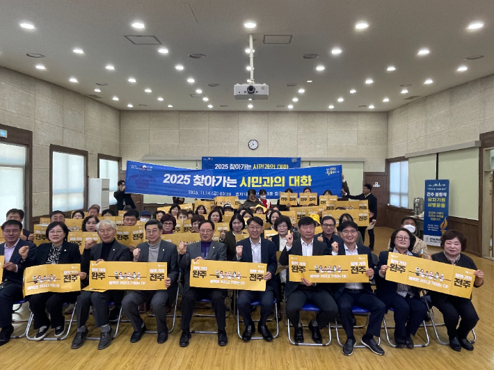 우범기 전주시장과 지역구 시의원, 주민들이 14일 효자1동 주민센터에서 열린 '2025 찾아가는 시민과의 대화'에서 완주-전주 통합을 염원하는 퍼포먼스를 하고 있다. 전주시 제공