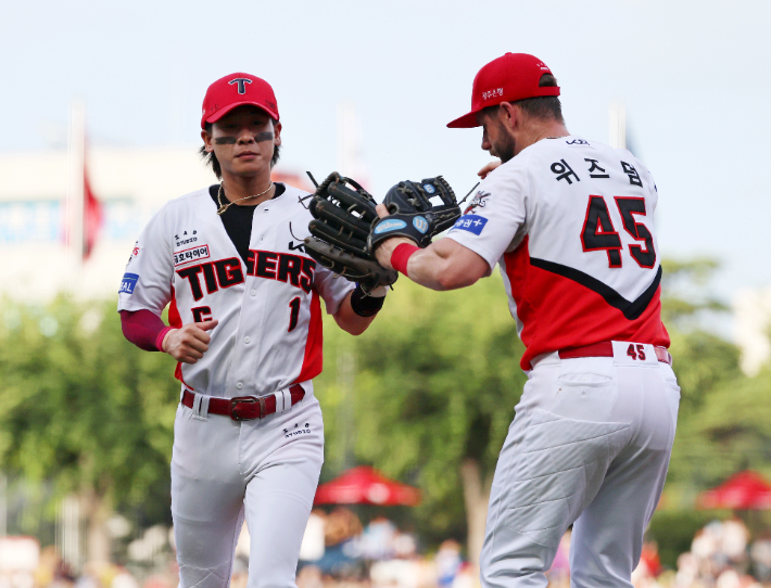 지난 7월 6일 광주기아챔피언스필드에서 열린 프로야구 롯데 자이언츠와 KIA 타이거즈의 경기. KIA 유격수 박찬호가 2회초 1사 1, 2루에서 롯데 장두성의 직선타구를 잡아 2루주자까지 더블아웃을 시킨 뒤 더그아웃으로 향하며 위즈덤의 환영을 받고 있다. 연합뉴스