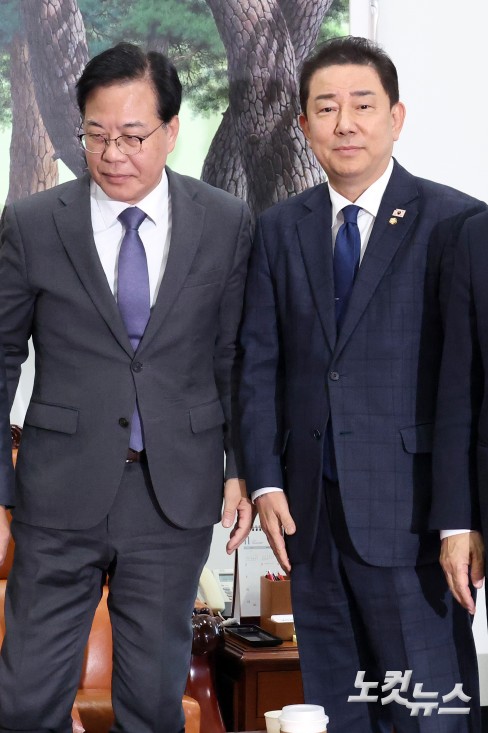 18일 서울 여의도 국회에서 더불어민주당 김병기 원내대표와 국민의힘 송언석 원내대표가 만나 악수를 하고 자리에 앉고 있다.
