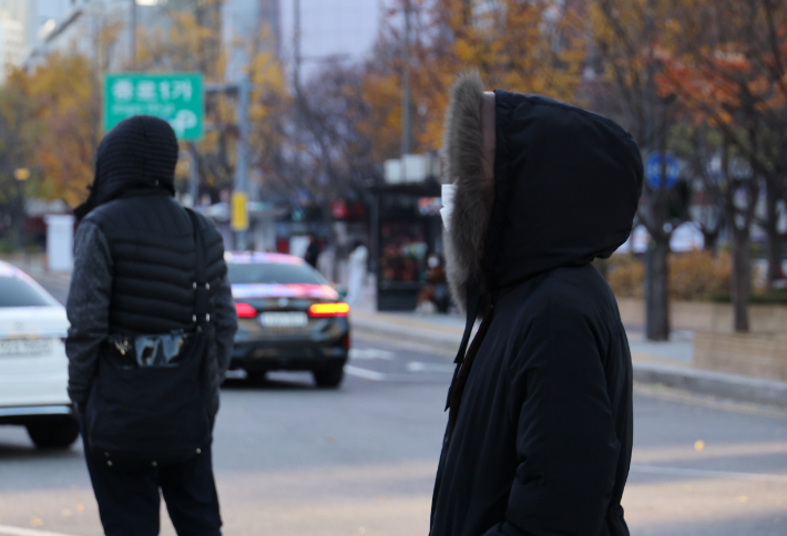 서울 아침 기온이 올가을 처음 영하로 내려가는 등 한파가 찾아온 18일 서울 광화문 거리에서 시민들이 발걸음을 재촉하고 있다. 연합뉴스