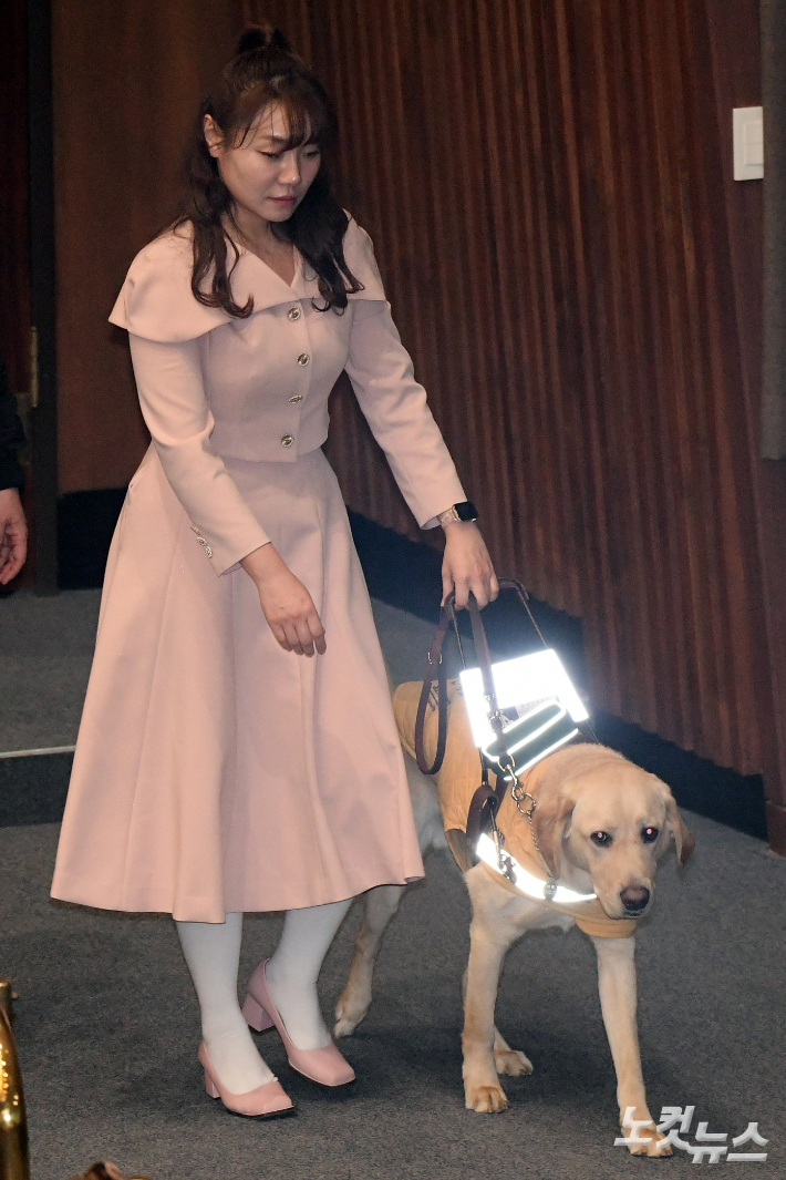 지난 2월 27일, 서울 여의도 국회에서 열린 제422회국회(임시회) 제7차 본회의에서 국민의힘 김예지 의원이 새 안내견 태백이와 이동하고 있다. 윤창원 기자