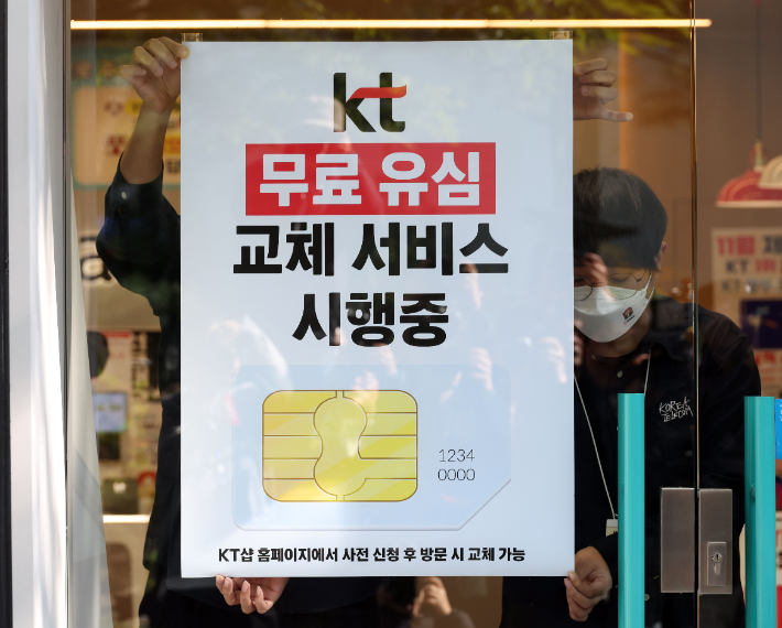 KT가 해킹 피해 후속 대책으로 전 가입자를 대상으로 무상 유심 교체를 시행한 5일 서울 시내 한 KT 대리점에서 직원들이 무료 유심 교체 서비스 시행 안내문을 부착하고 있다. 황진환 기자