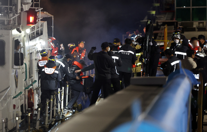 19일 오후 전남 목포시 목포해양경찰서 전용 부두로 여객선 퀸제누비아2호 탑승객들이 구조돼 이동하고 있다. 267명이 탑승한 퀸제누비아2호는 이날 오후 8시 17분께 전남 신안군 장산도 남방 족도에 좌초됐다. 연합뉴스