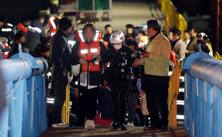 지난 19일 오후 전남 목포시 목포해양경찰서 전용 부두로 여객선 퀸제누비아2호 탑승객들이 구조돼 이동하는 모습. 연합뉴스