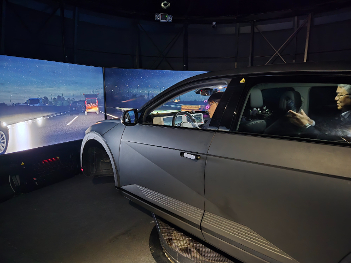 지난 19일 AI집적단지 열린 '대형 드라이빙 시뮬레이터 테크(TECH) 세미나'에서 모빌리티 분야 기관 관계자들이 대형 드라이빙 시뮬레이터를 체험하고 있다. 인공지능산업융합사업단 제공