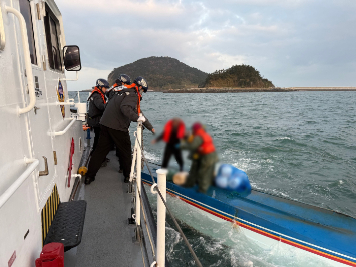 전복된 어선에서 선원을 구조하고 있는 해경의 모습. 전북 군산해양경찰서 제공