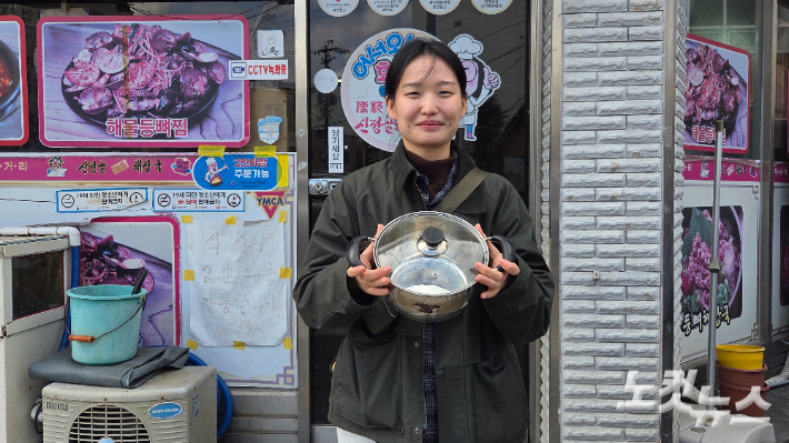 순천의 한 식당 앞에서 직접 가져온 냄비를 들고 환하게 웃는 이도현씨. 박사라 기자  