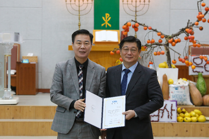 전북CBS 이균형 대표가 신임 이사장으로 취임한 진재성 목사에게 위촉장을 전달하고 있다. 최화랑 기자
