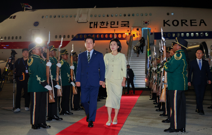 주요 20개국(G20) 정상회의에 참석하는 이재명 대통령이 김혜경 여사와 함께 21일(현지시간) 남아프리카공화국 요하네스버그 OR탐보국제공항에 도착한 뒤 공군 1호기에서 내려 이동하고 있다. 연합뉴스
