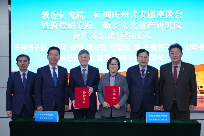 주낙영 경주시장과 이동협 시의회 의장이 중국 둔황연구원에서 신라문화유산연구원과 둔황연구원 간 학술 협력을 위한 MOU를 체결한 뒤 관계자들과 기념촬영을 하고 있다. 경주시 제공