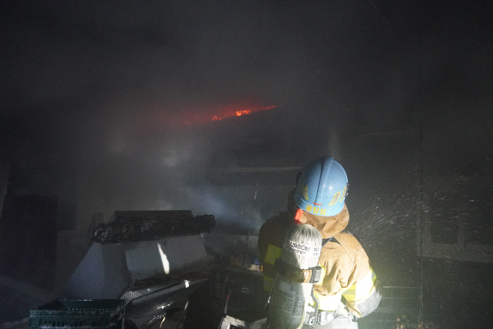 지난 23일 오후 10시 25분쯤 경기 양주시 고암동의 한 자동차정비소에서 난 불을 소방관이 진화하고 있다. 경기북부소방재난본부 제공