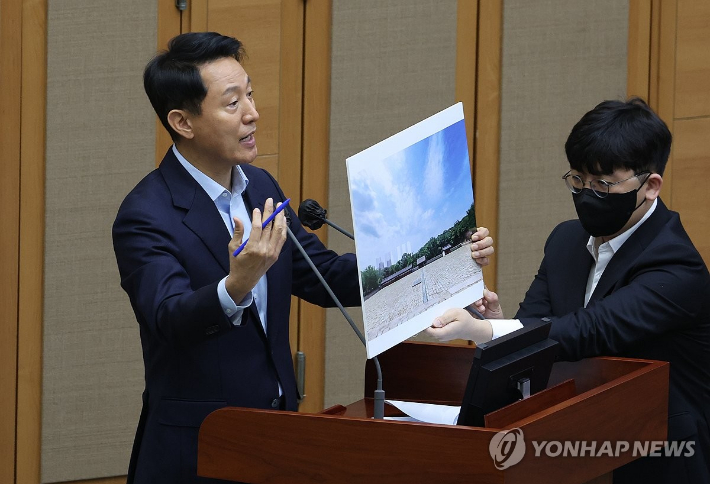 오세훈 서울시장이 18일 서울 중구 서울시의회에서 열린 제333회 정례회 시정질문에 참석, 세운4구역 재개발과 관련된 자료를 들고 질의에 답하고 있다. 연합뉴스