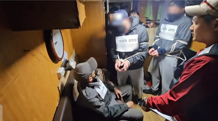 부산에 정박 중인 원양어선에서 동료 선원을 폭행해 숨지게 한 피의자들이 집단 폭행을 재현하고 있다. 부산해양경찰서 제공