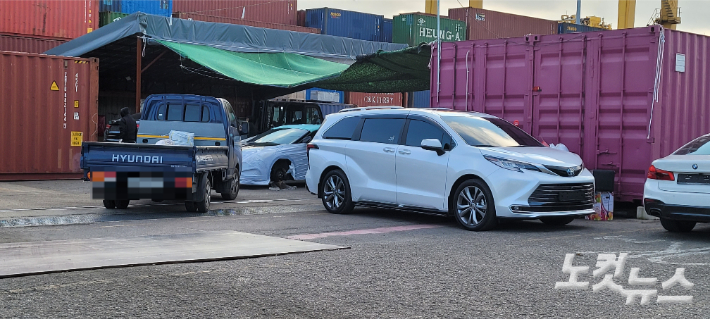 해당 항만 배후단지에서 외국인노동자 등이 중고차 선적 작업을 하고 있는 모습. 박창주 기자