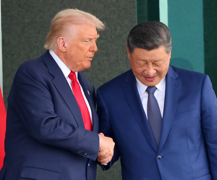 도널드 트럼프 미국 대통령과 시진핑 중국 국가주석이 지난달 30일 부산 김해공군기지 의전실 나래마루에서 미중 정상회담을 마친 뒤 회담장을 나서며 악수하고 있다. 연합뉴스