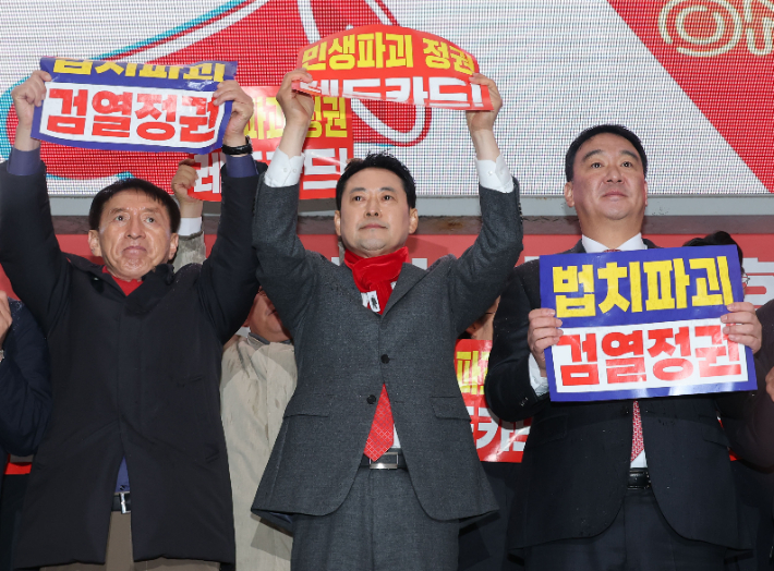 국민의힘 장동혁 대표를 비롯한 당 지도부, 소속 의원들이 25일 구미역 광장에서 열린 민생회복과 법치수호 경북 국민대회에서 팻말을 들고 있다. 연합뉴스