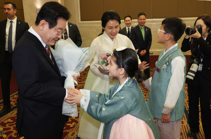 튀르키예를 국빈 방문 중인 이재명 대통령과 김혜경 여사가 25일(현지시간) 앙카라의 한 호텔에서 열린 동포·지상사 간담회에서 화동으로부터 꽃다발을 받고 있다. 연합뉴스