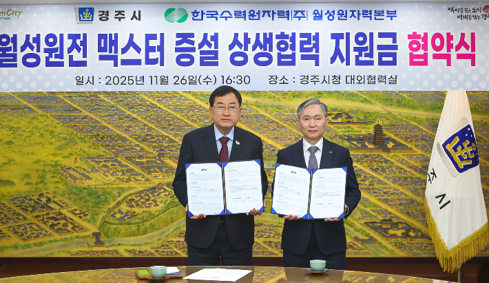 주낙영 경주시장(왼쪽)과 권원택 한국수력원자력 월성원자력본부장이 경주시청 대외협력실에서 월성원전 맥스터 증설 상생협력 지원금 협약을 체결한뒤 협약서를 들어 보이고 있다. 경주시 제공