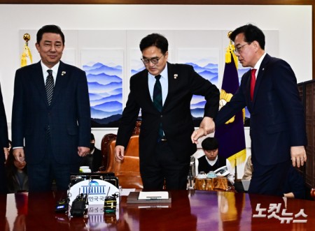 우원식 국회의장이 27일 오전 서울 여의도 국회에서 열린 여야 원내대표 회동에 참석해 사진촬영을 거부하는 송언석 국민의힘 원내대표에게 참여를 권하고 있다.