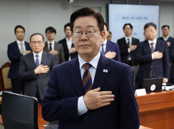 이재명 대통령이 27일 서울 용산 대통령실에서 열린 수석보좌관회의에서 국기에 경례하고 있다. 연합뉴스