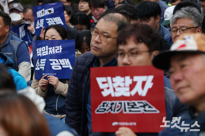 전국공무원노조 조합원들이 지난달 21일 오후 서울 여의도 산업은행 앞에서 열린 정치기본권 쟁취·소득공백 해소 총력투쟁대회에서 '되찾자 정치기본권' 등이 적힌 피켓을 들고 있다. 류영주 기자
