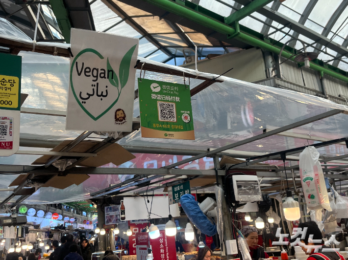 영어·중국어 안내문과 위챗페이 등 간편결제 QR코드가 걸린 노점가. 외국인 관광객을 의식한 결제·메뉴 환경이 광장시장 곳곳에 자리잡고 있다. 권유빈 인턴기자