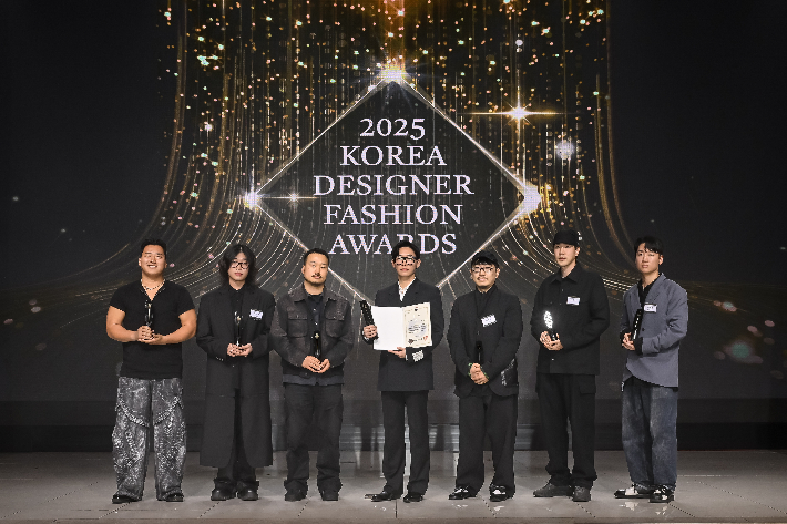 2025 한국디자이너패션어워즈 수상 디자이너들이 기념촬영을 하고 있다. 왼쪽부터 유강현, 박상조, 김지용, 김인태, 김지만, 이진호, 장세훈. 한국패션디자이너연합회 제공 