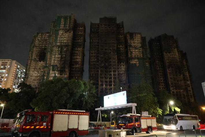 29일(현지시간) 대형 화재가 일어났던 홍콩 북부 타이포 지역의 고층 아파트 단지 웡 푹 코트 앞에 소방차가 주차돼 있다. 연합뉴스