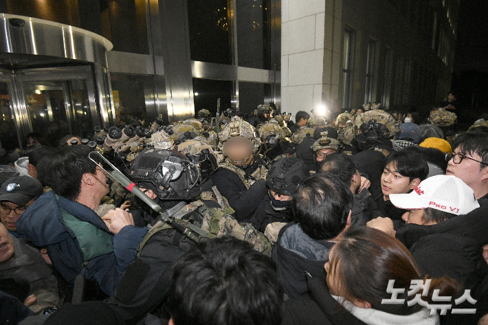 윤석열 전 대통령이 지난해 12월 3일 밤 비상계엄을 선포한 가운데 4일 새벽 서울 여의도 국회에서 경내로 진입하려는 계엄군과 저지하려는 시민 및 국회 관계자들이 대치하고 있다. 박종민 기자