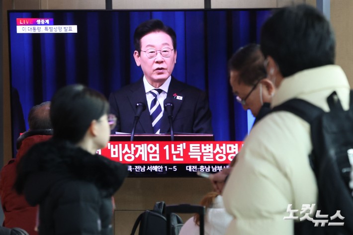 12·3 비상계엄 1년을 맞은 3일 오전 서울 중구 서울역 대합실에서 시민들이 이재명 대통령의 
