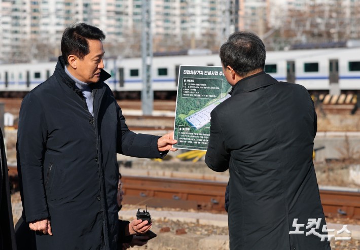오세훈 서울시장이 3일 서울 노원구 서울교통공사 창동차량기지에서 열린 진접차량기지 시험운행 개시 기념행사에서 관계자의 서울 디지털바이오시티 조성 계획 관련 브리핑을 듣고 있다.