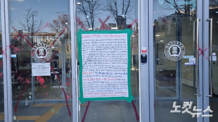 3일 오후 동덕여자대학교 남녀공학 전환 외부 연구 용역 결과 발표회가 열리는 학교 백주년 기념관에 학생의 대자보가 붙어있다. 유리문에는 1년 전의 '래커칠 시위' 흔적이 남아 있다. 김지은 기자