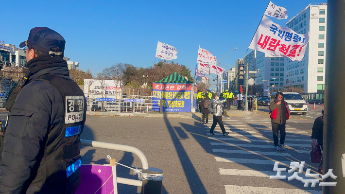 서울 여의도 국회 정문 앞에서 시민들이 깃발을 들고 시위를 벌이고 있다. 권유빈 인턴기자