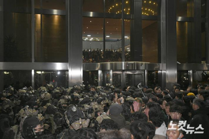 윤석열 전 대통령이 지난해 12월 3일 밤 비상계엄을 선포한 가운데 4일 새벽 서울 여의도 국회에서 경내로 진입하려는 계엄군과 저지하려는 시민 및 국회 관계자들이 대치하고 있다. 박종민 기자