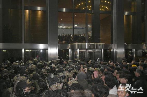 윤석열 전 대통령이 지난해 12월 3일 밤 비상계엄을 선포한 가운데 4일 새벽 서울 여의도 국회에서 경내로 진입하려는 계엄군과 저지하려는 시민 및 국회 관계자들이 대치하고 있다. 박종민 기자