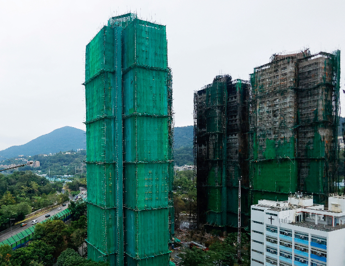 3일(현지시간) 홍콩 북부 아파트 화재 뒤 보호망으로 덮여 있는 아파트. 연합뉴스