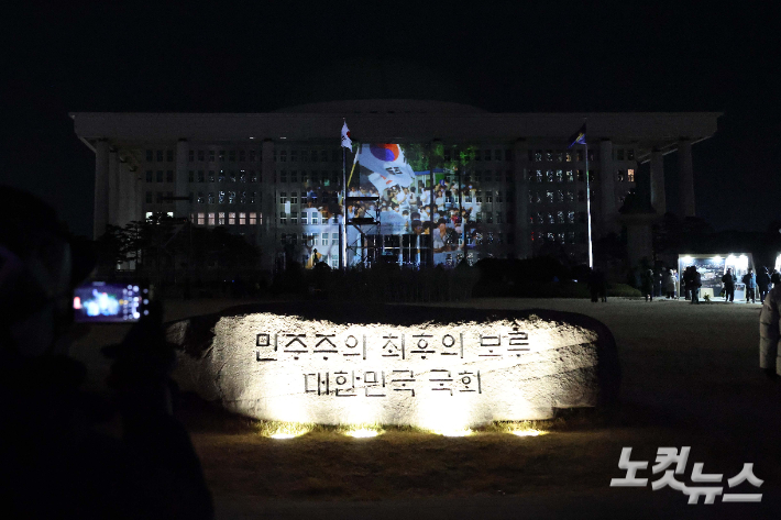12·3 비상계엄 1년을 맞은 3일 오후 서울 영등포구 국회의사당에 계엄 해제 당시 기억을 되새기는 '미디어 파사드'가 펼쳐지고 있다. 박종민 기자
