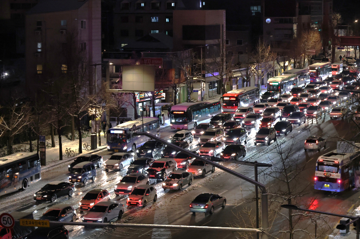 올겨울 많은 양의 첫눈이 내린 4일 23시께 서울 종로구 경복궁역 인근에서 시내로 향하는 차량이 눈길에 정체를 빚고 있다. 연합뉴스
